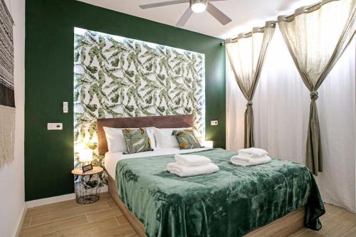 Un dormitorio verde con una cama con toallas. en Royal Suite Diamantes I With heated pool en Los Cristianos