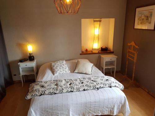 1 dormitorio con 1 cama, 2 mesas y espejo en Les Souchottes, charmante maisonnette en Bulligny