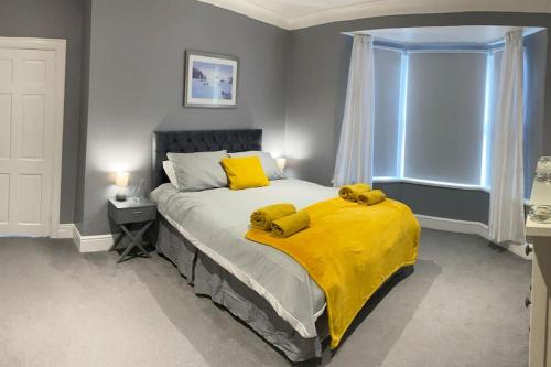 a bedroom with a bed with a yellow blanket on it at Seaside House-Next to the Beach, Sleeps 6 in South Shields