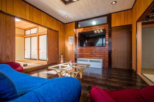 a living room with a blue couch and a table at Engawa House Momiji-With hot spring in Fujikawaguchiko