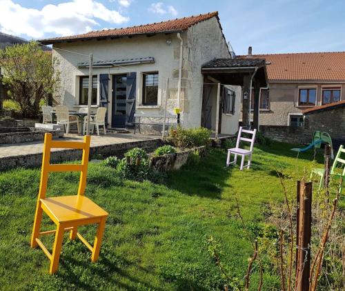 a yellow chair in the yard of a house at Les Souchottes, charmante maisonnette in Bulligny