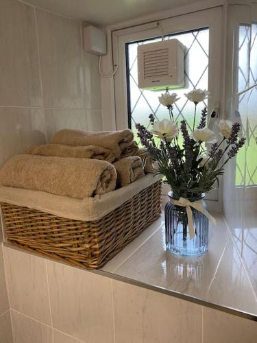 a bathroom with towels and a vase of flowers on a counter at The Old Thatch, Lemybrien in Waterford