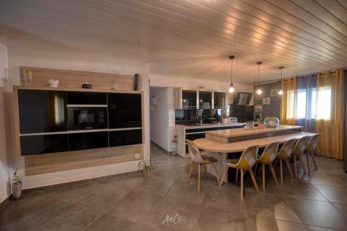 cocina con mesa y sillas en una habitación en HAUT DE VILLA avec piscine chez JP, en Petite Île