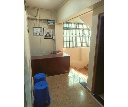 a room with a desk and two blue stools at Aqua Horizon in Port Blair