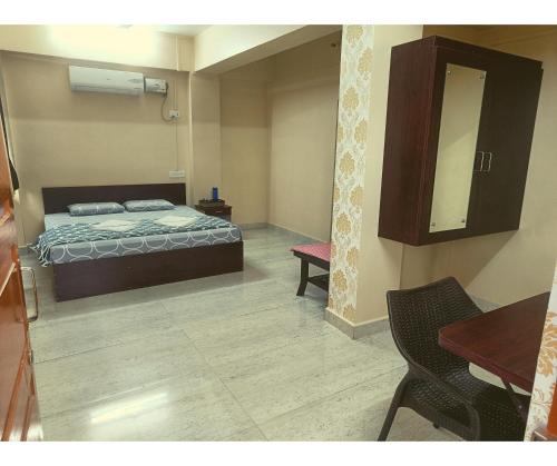 a bedroom with a bed and a table and a mirror at Aqua Horizon in Port Blair