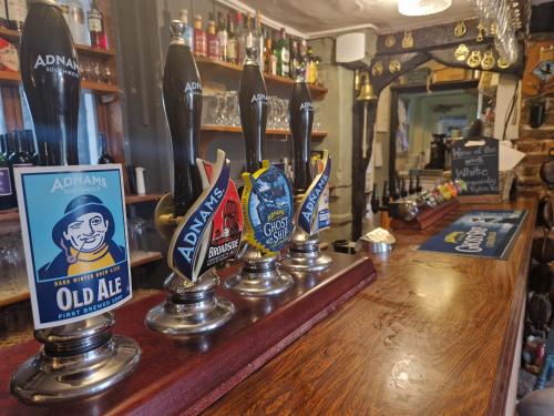 eine Bar mit einem Haufen Auszeichnungen auf dem Tresen in der Unterkunft The Jolly Sailor, Orford in Orford