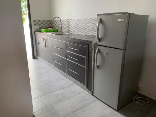 a kitchen with a stainless steel refrigerator and a counter at Studio Les Hirondelles in Ngaparou