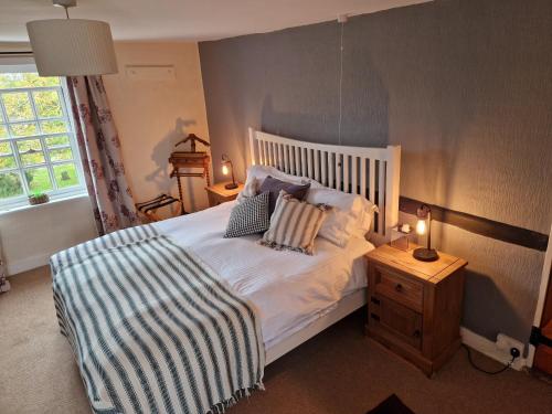a bedroom with a white bed with pillows on it at The Jolly Sailor, Orford in Orford