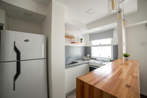 een keuken met een witte koelkast en een houten aanrecht bij Corrientes Suites in Mar del Plata