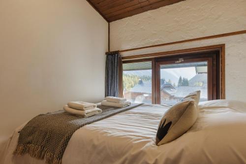 a bedroom with a large bed with towels on it at La Maison De Montroc - Happy Rentals in Chamonix-Mont-Blanc