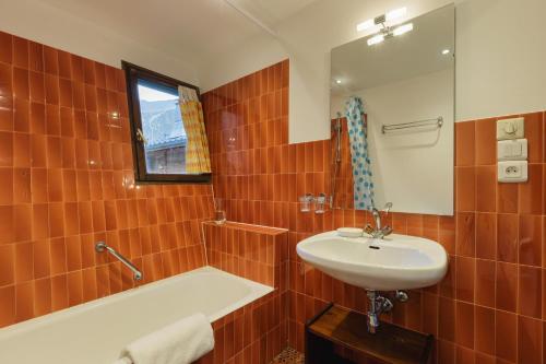 a bathroom with a sink and a tub and a mirror at La Maison De Montroc - Happy Rentals in Chamonix