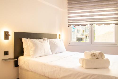 a bedroom with a white bed with towels on it at Vibran in Izmir