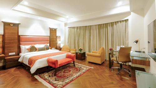 ein Hotelzimmer mit einem Bett und einem Schreibtisch in der Unterkunft Best Western Merrion in Amritsar