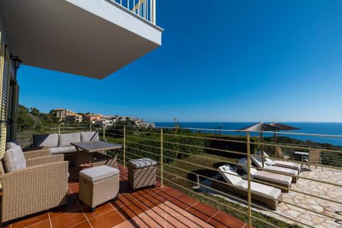 a balcony with chairs and a view of the ocean at Astra Villas in Skala Kefalonias