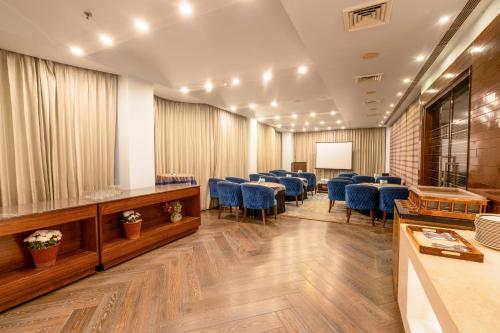a conference room with tables and blue chairs at Best Western Merrion in Amritsar