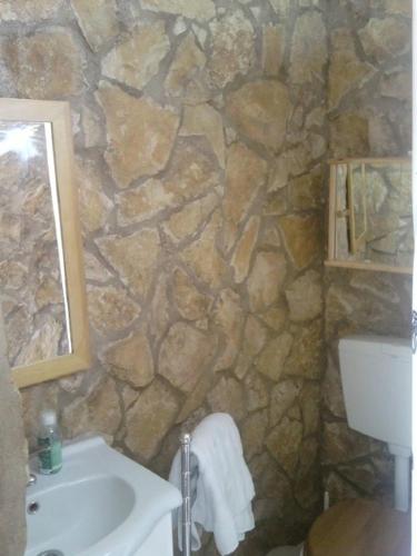 a stone bathroom with a sink and a mirror at Casa Bi Rosario - Quinta Amoreira in Faro