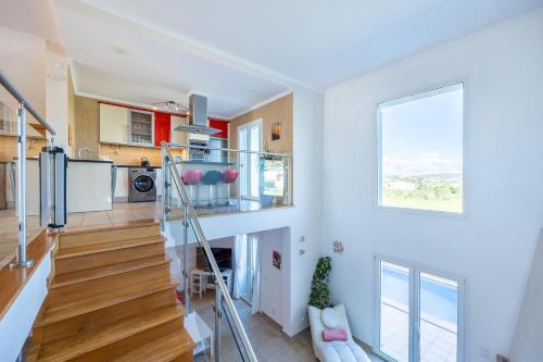 a living room with a staircase and a kitchen at Your Villa Algarve Private pool 5 min walk to beach in Burgau