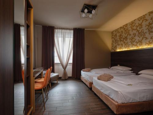 a hotel room with two beds and a desk at Hotel Giulietta in Verona