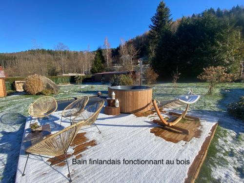 een groep stoelen rond een vuurplaats bij Gîte Chalet avec bain nordique et piscine 11 pers Hautes Vosges in Plainfaing