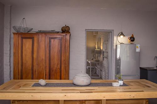 a kitchen with a wooden table and a refrigerator at Dragon Tree in Yzerfontein