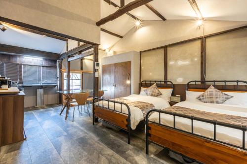 大阪市にあるrent tsuruhashiのベッド2台とテーブルと椅子のある寝室