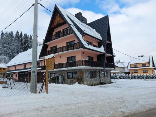 a building with a snow covered roof in the snow at u Marii Gał in Leśnica