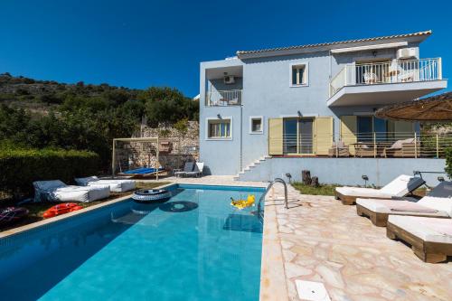 a swimming pool in front of a house at Astra Villas in Skala Kefalonias