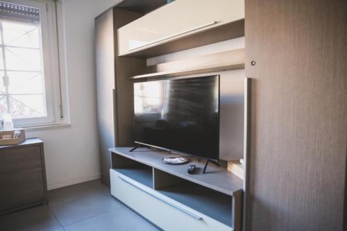 a living room with a television on a shelf at Grey House Pavia con Box Privato in Pavia