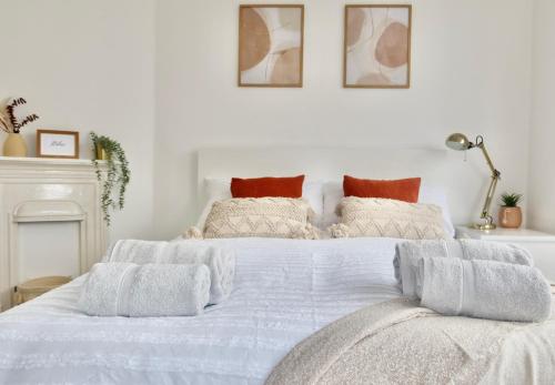 Hampton House - Sleeps 7 - Free Parking and WiFi في بريستول: سرير أبيض عليه أغطية ووسائد بيضاء