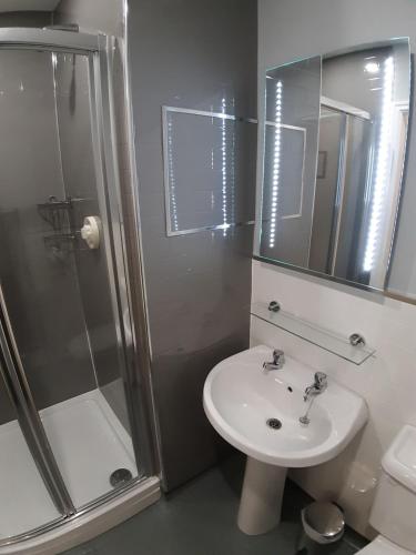 a bathroom with a sink and a shower and a toilet at Hanover Hotel & McCartney's Bar in Liverpool