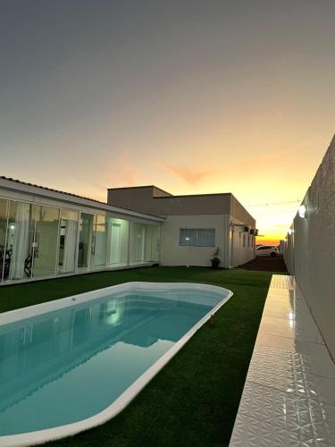 een huis met een zwembad in de tuin bij Pousada Carmel in Ametista do Sul