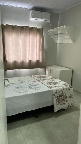 een klein bed in een kamer met een raam bij Pousada Carmel in Ametista do Sul