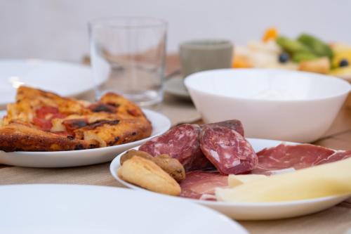 a table with two plates of food on it at Milestones Modern Suite Trullo Jacuzzi Spa & Relax in Alberobello
