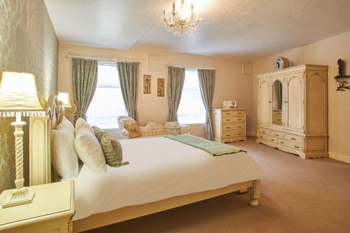 a bedroom with a large white bed and a chandelier at Host & Stay - Regency Mansions Apartment in Redcar