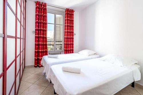 - 2 lits dans une chambre avec fenêtre et rideaux rouges dans l'établissement C047-Studio de charme proche Palais des Festivals, à Cannes