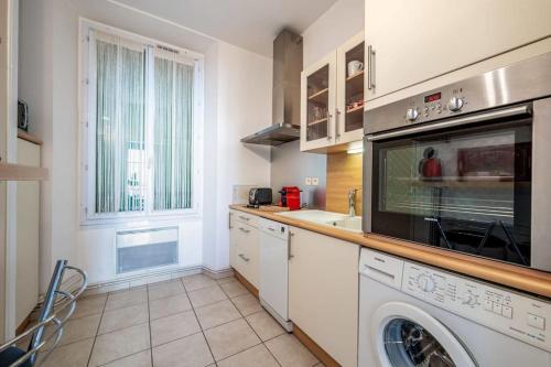 une cuisine avec une machine à laver et un lave-vaisselle dans l'établissement C047-Studio de charme proche Palais des Festivals, à Cannes
