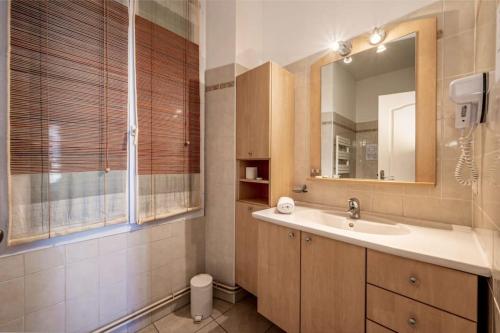 une salle de bain avec un lavabo et un miroir dans l'établissement C047-Studio de charme proche Palais des Festivals, à Cannes