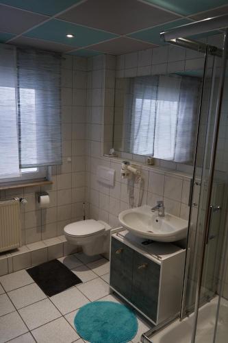 a bathroom with a sink and a toilet and a mirror at Hotel Auszeit im Euro Rastpark Guxhagen in Guxhagen