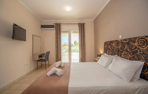 a hotel room with a bed with towels on it at DENNIS and TANYA VILLAS in Laganas