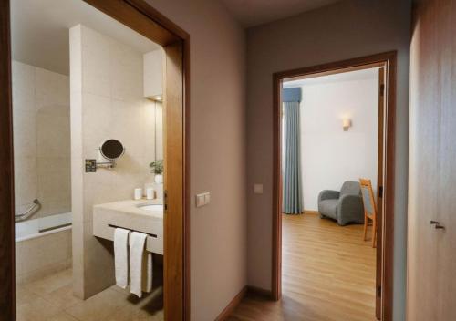 La salle de bains est pourvue d'un lavabo, de toilettes et d'une baignoire. dans l'établissement Montebelo Palácio dos Melos Viseu Historic Hotel, à Viseu