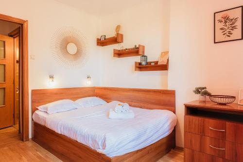 una camera da letto con un letto grande con lenzuola bianche di Romanian Athenaeum 1BR Apartment with Amazing View a Bucarest