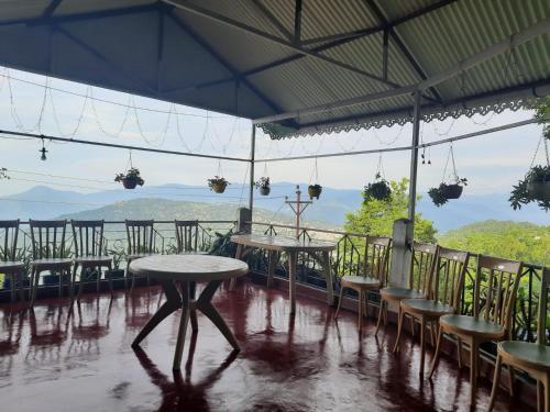 um pátio com mesas e cadeiras e vista para as montanhas em Kalimpong View Stay em Kalimpong