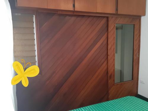 una puerta de madera con una mariposa amarilla. en Depto. 1 ambiente Plaza Mitre en Mar del Plata