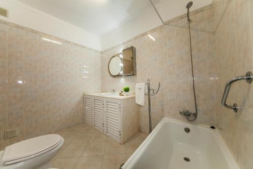 a bathroom with a tub and a toilet and a sink at Apartment T2 Alvor in Alvor