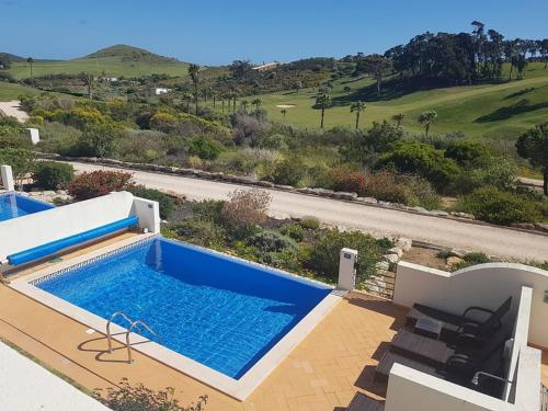 - une grande piscine à côté d'une villa dans l'établissement Stunning 3 bed villa with pool- Golf Beach, à Budens