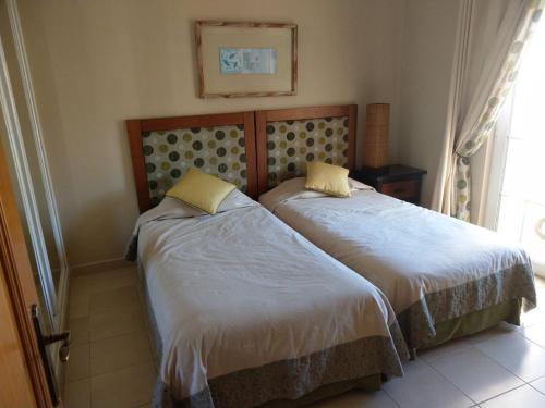 2 letti posti uno accanto all'altro in una camera da letto di Stunning 3 bed villa with pool- Golf Beach a Budens