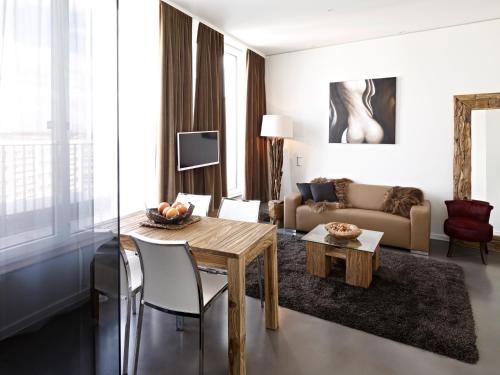 a living room with a table and a couch at VISIONAPARTMENTS Berlin - contactless check-in in Berlin