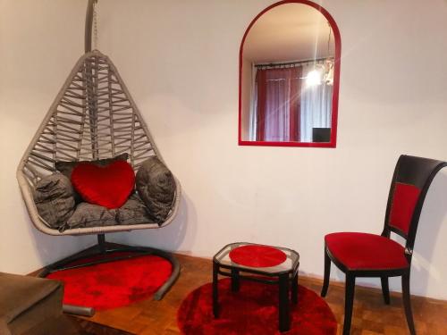 Zimmer mit einer Herzschaukel mit 2 Stühlen und einem Spiegel in der Unterkunft Apartman stan na dan Sarajevo in Sarajevo