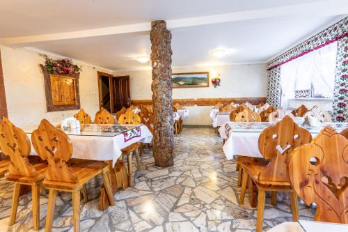 un restaurante con mesas y sillas y un pilar en DW Paweł, en Zakopane