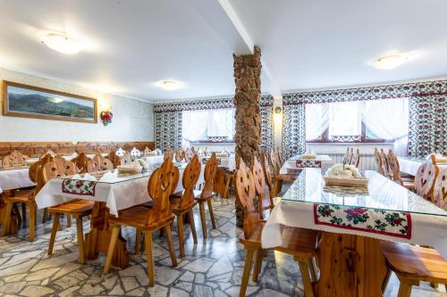 a restaurant with wooden tables and chairs and windows at DW Paweł in Zakopane